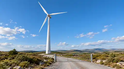 Bir rüzgâr türbininin tabanı, bakım yolu ve çevredeki açık arazi.